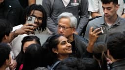 Jensen Huang, CEO da Nvidia, cercado por estudantes que tiram fotos com ele após palestra em Stanford