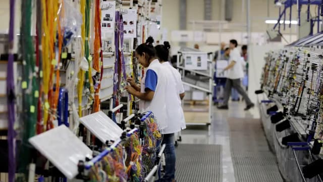 Trabalhadores em linha de montagem de fábrica no Brasil