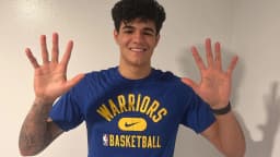 Gui Santos sorri com as mãos abertas vestindo camisa do Golden State Warriors, em foto de arquivo de 2022