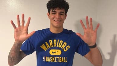Gui Santos sorri com as mãos abertas vestindo camisa do Golden State Warriors, em foto de arquivo de 2022