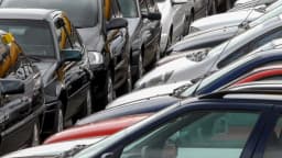 Fileira de veículos novos estacionados, prontos para exportação