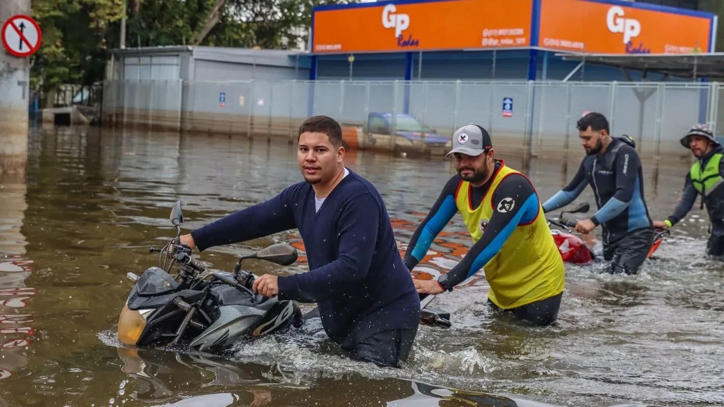 Pessoas atravessam rua alagada em Porto Alegre durante enchente do Guaíba (foto de arquivo, maio de 2024)