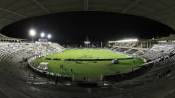 Vista panorâmica de São Januário durante partida noturna, com o gramado iluminado e torcida nas arquibancadas