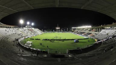Vista panorâmica de São Januário durante partida noturna, com o gramado iluminado e torcida nas arquibancadas