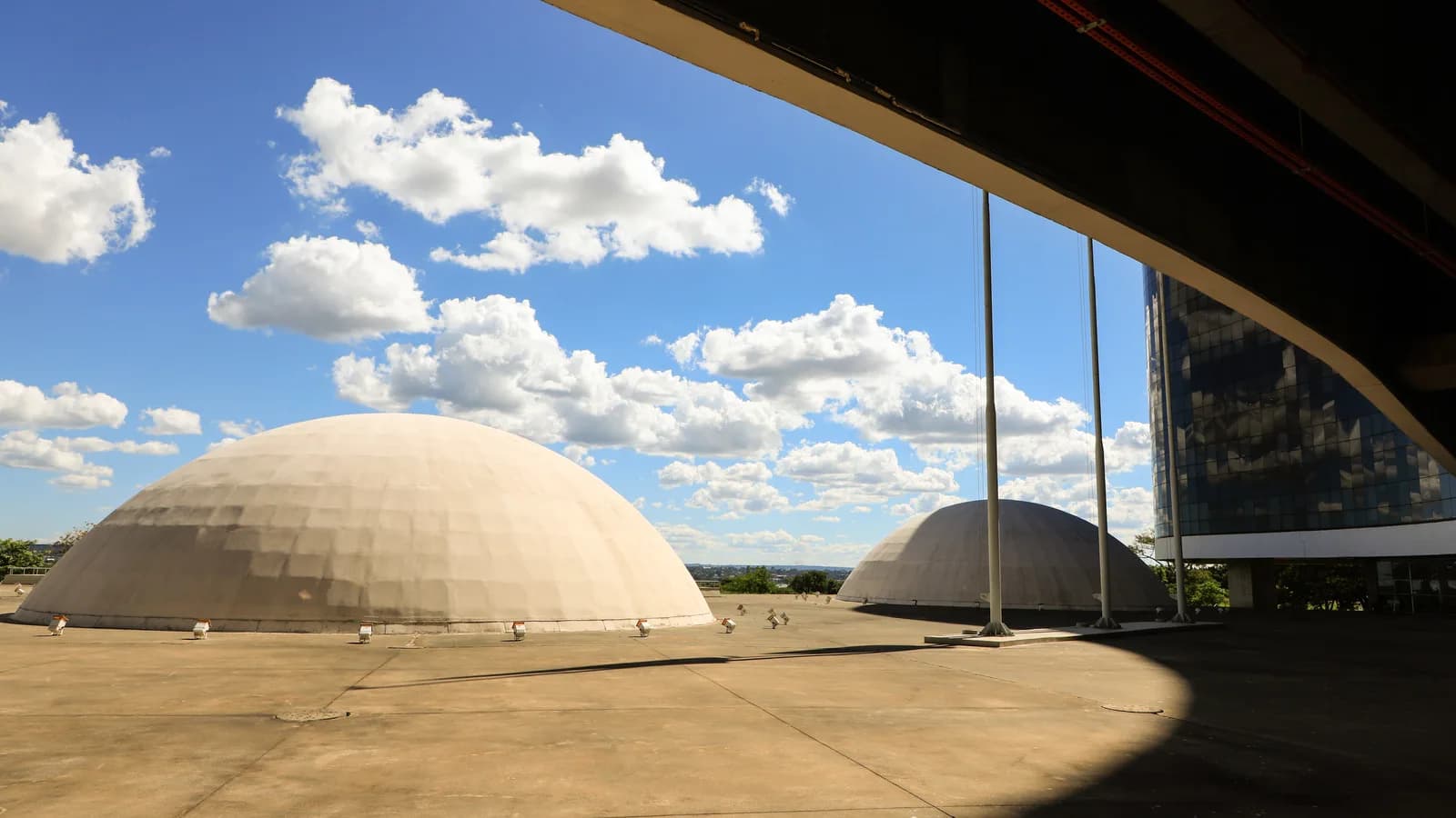 Fachada da sede do Tribunal Superior Eleitoral, em Brasília, sob céu azul com nuvens