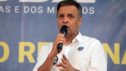 Aécio Neves discursa ao microfone em evento de campanha do PSDB em Minas Gerais
