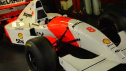 Carro clássico de Fórmula 1 da McLaren, branco e vermelho, em exposição