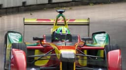 Carro de Fórmula E de Lucas Di Grassi, nas cores vermelho, amarelo e verde, em corrida de rua em Londres