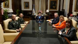 Javier Milei reunido com integrantes do governo argentino em sala com bandeira da Argentina