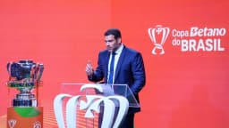 Samir Xaud, presidente da CBF, fala ao microfone ao lado da taça da Copa do Brasil durante o evento desta quinta-feira (10).