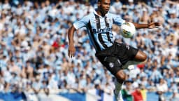 Jogador do Grêmio disputa bola durante clássico Gre-Nal com a torcida ao fundo (foto de arquivo, 2012)