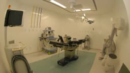 Sala de cirurgia equipada, com mesa cirúrgica e aparelhos médicos