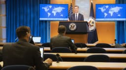 Sala de coletivas do Departamento de Estado dos EUA em Washington, com porta-voz ao pódio e jornalistas em primeiro plano