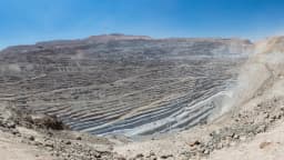 Vista panorâmica de uma mina de cobre a céu aberto, com terraços escavados na rocha