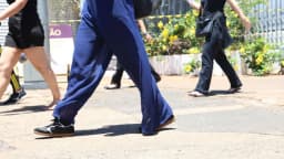 Candidatos caminham em via pública após deixar local de prova de concurso público, em foto de arquivo