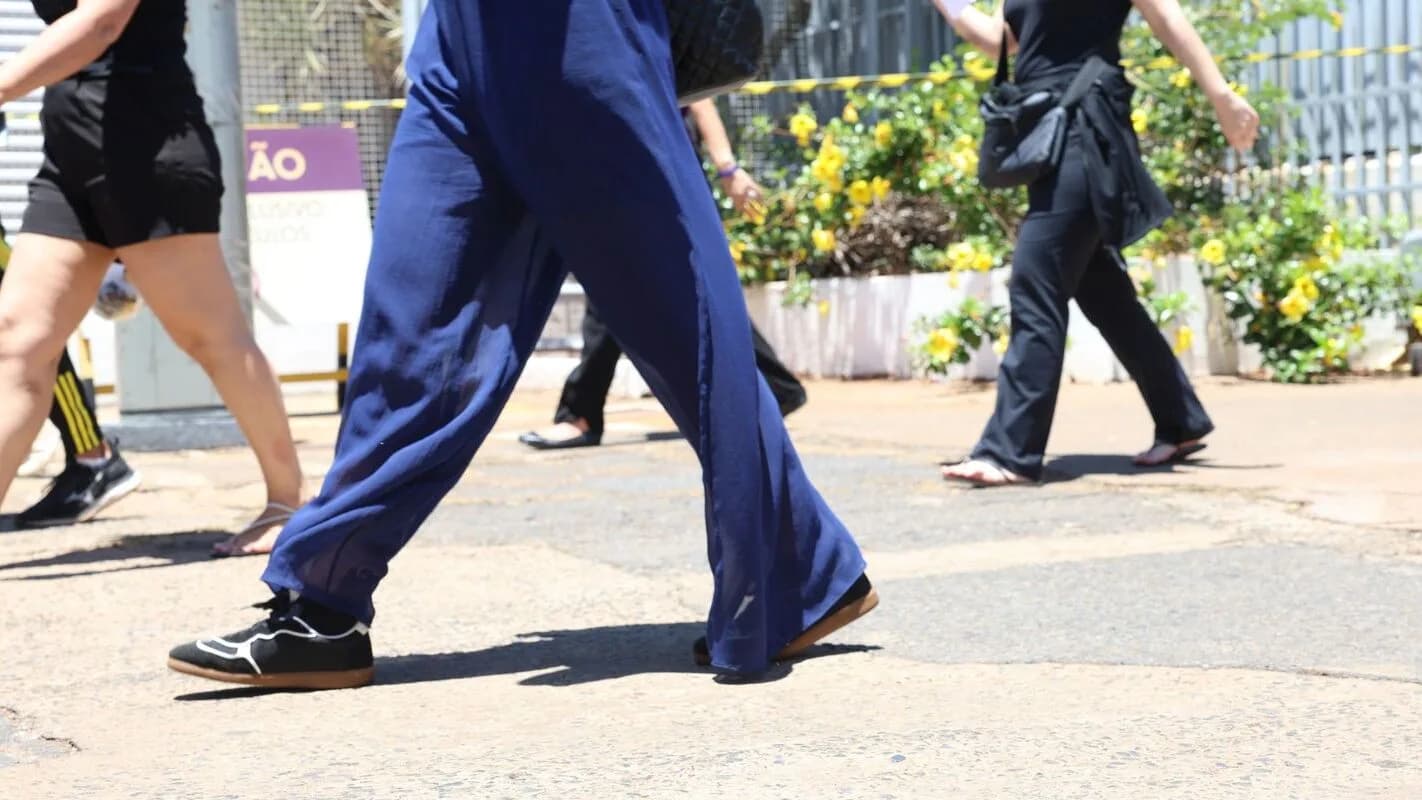Candidatos caminham em via pública após deixar local de prova de concurso público, em foto de arquivo