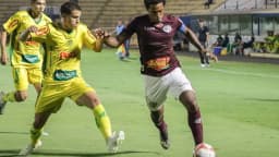 Jogador da Ferroviária, de grená, disputa a bola com adversário do Mirassol em partida da Série D