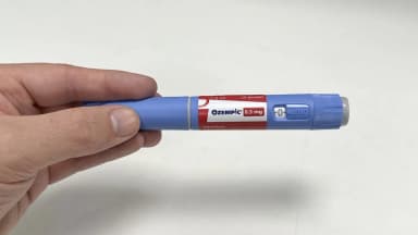 Mão segurando uma caneta injetável de Ozempic (semaglutida), medicamento da classe GLP-1 usado no tratamento de diabetes e obesidade