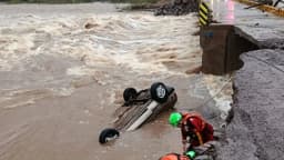 Carro arrastado por enchente e bombeiro em ação durante resgate no Rio Grande do Sul (foto de arquivo)