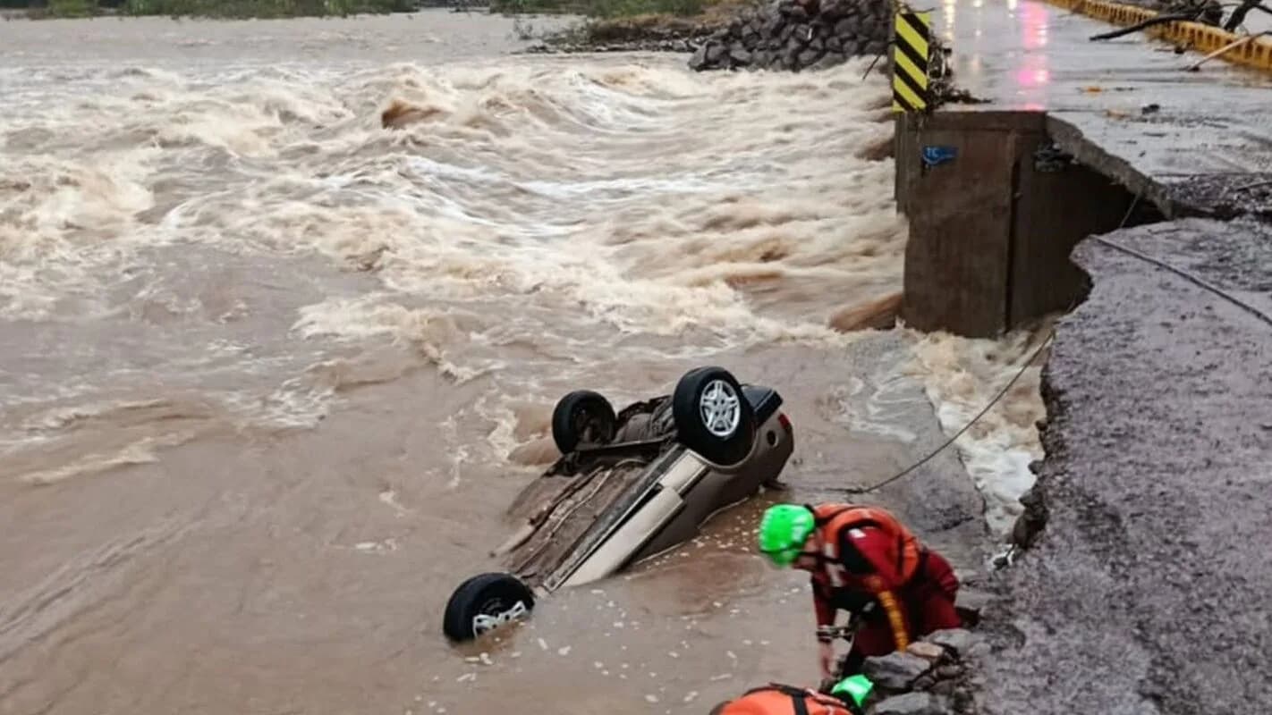 Carro arrastado por enchente e bombeiro em ação durante resgate no Rio Grande do Sul (foto de arquivo)