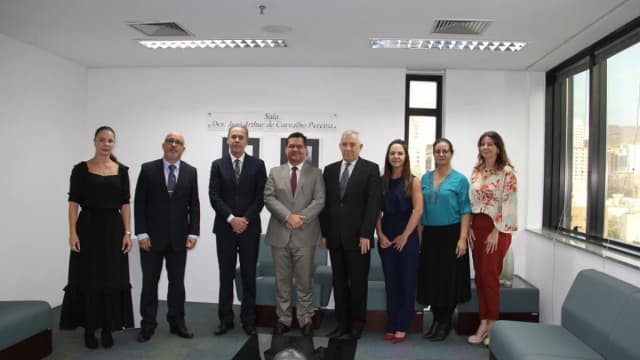 Grupo de autoridades do TRE-MG posa em sala de reunião durante assinatura de acordo de cooperação