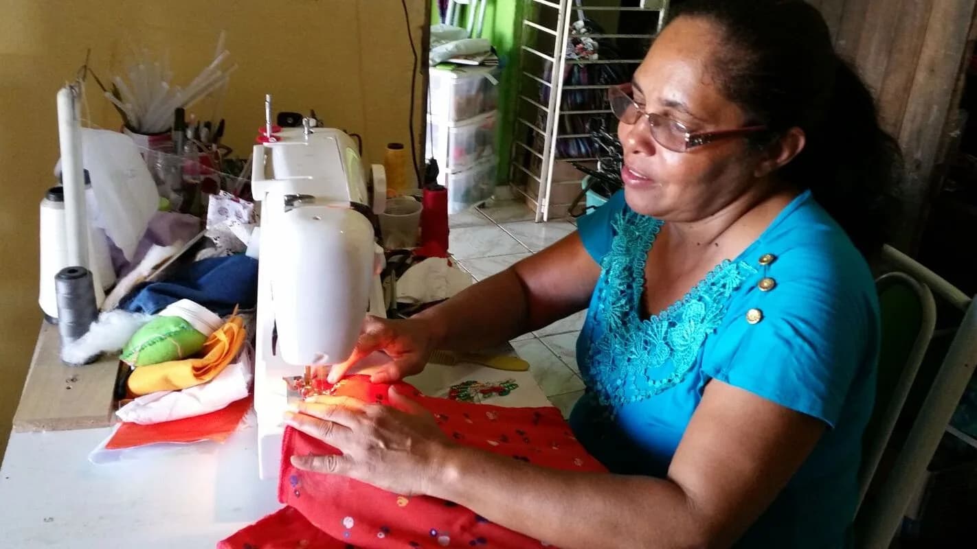 Pequena empreendedora trabalha em sua máquina de costura (foto de arquivo)