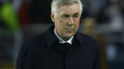 Técnico Carlo Ancelotti observa o jogo em campo, com expressão séria