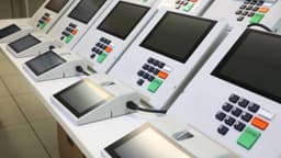 Fileira de urnas eletrônicas do TSE prontas para uso em eleição