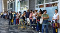 Fila de candidatos aguarda para entrar em local de prova de concurso público