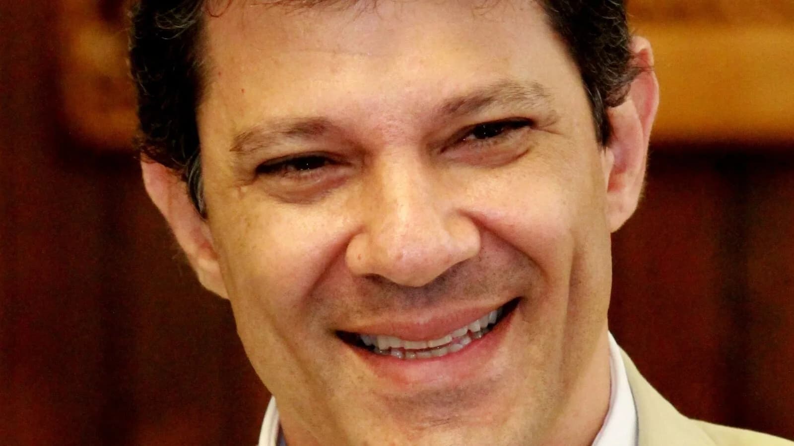 Fernando Haddad sorrindo em retrato durante evento público