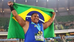 Alessandro Borges sorri e segura a bandeira do Brasil aberta, com a medalha de ouro no pescoço, durante o Mundial Sub-20 de Atletismo em Eugene, no Oregon