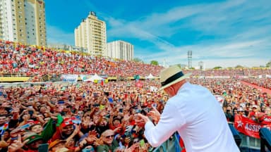 Lula, de chapéu de palha, acena de costas para multidão durante lançamento da campanha em São Bernardo do Campo
