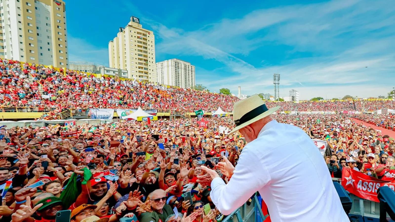 Lula, de chapéu de palha, acena de costas para multidão durante lançamento da campanha em São Bernardo do Campo