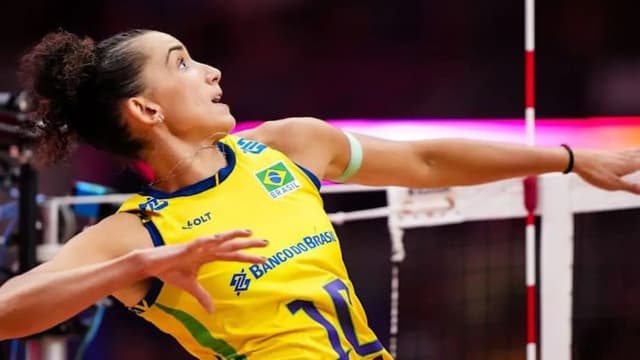 Gabi Guimarães, capitã da seleção brasileira, ataca durante partida de vôlei com o uniforme amarelo da seleção