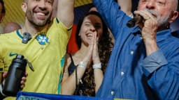 Lula ergue o punho ao lado de bandeira do Brasil em comemoração à reeleição