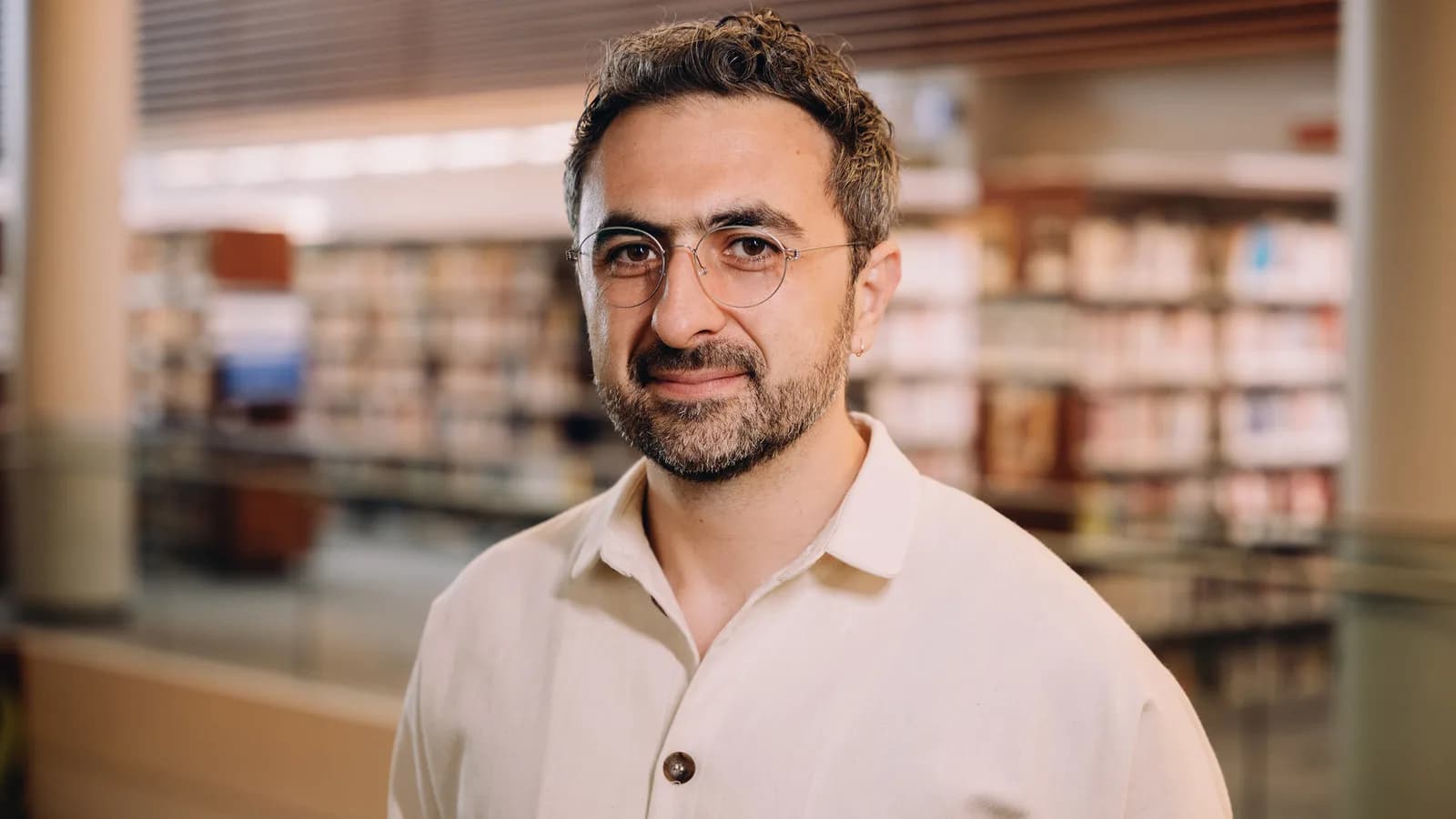 Retrato de Mustafa Suleyman, chefe de IA da Microsoft, usando óculos