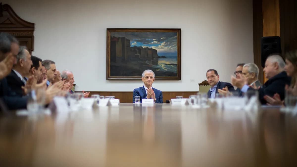 Executivos reunidos em sala de reunião assinando documentos