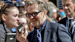 Gary Oldman sorri para fãs durante evento em tapete vermelho