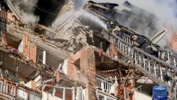 Bombeiro combate incêndio em prédio residencial destruído por ataque russo em Kharkiv, na Ucrânia