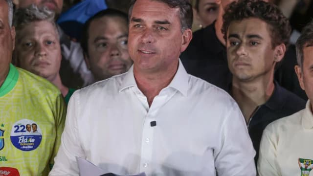 Flávio Bolsonaro em coletiva de imprensa, cercado por apoiadores