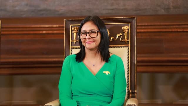 Delcy Rodríguez sentada em cadeira oficial durante cerimônia na Venezuela