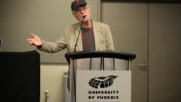 Tom Skerritt discursa em pódio durante evento público