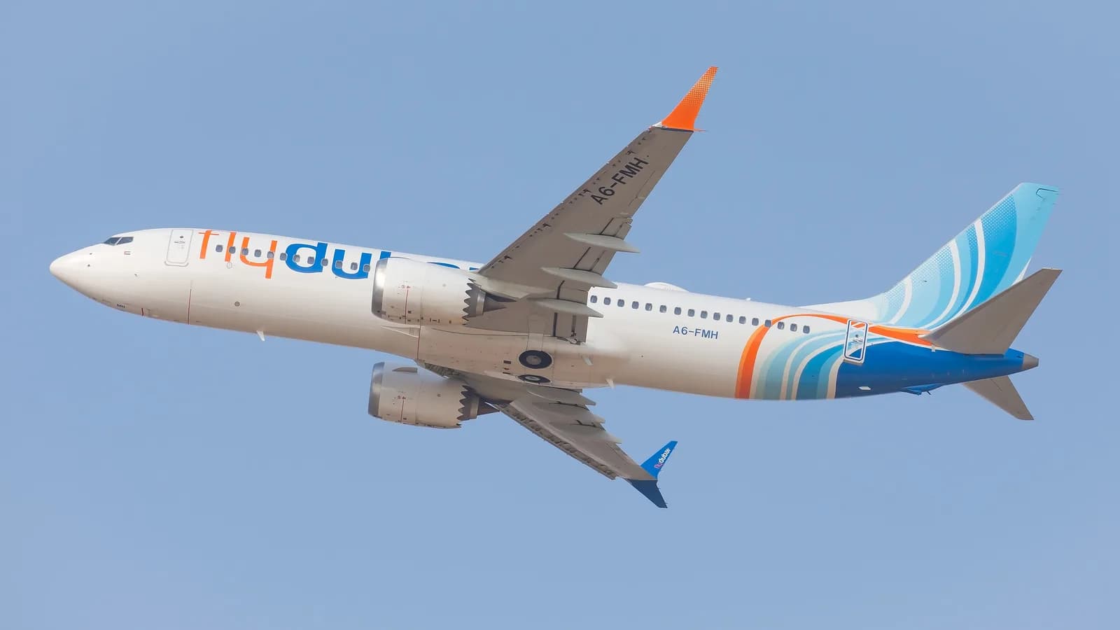 Avião da Flydubai decolando, com a pintura característica azul e laranja da companhia