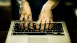 Mãos digitando em teclado de notebook, em foto que simboliza ataque hacker