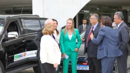 A governadora do DF, Celina Leão, de terno verde, conversa com autoridades ao lado de uma viatura