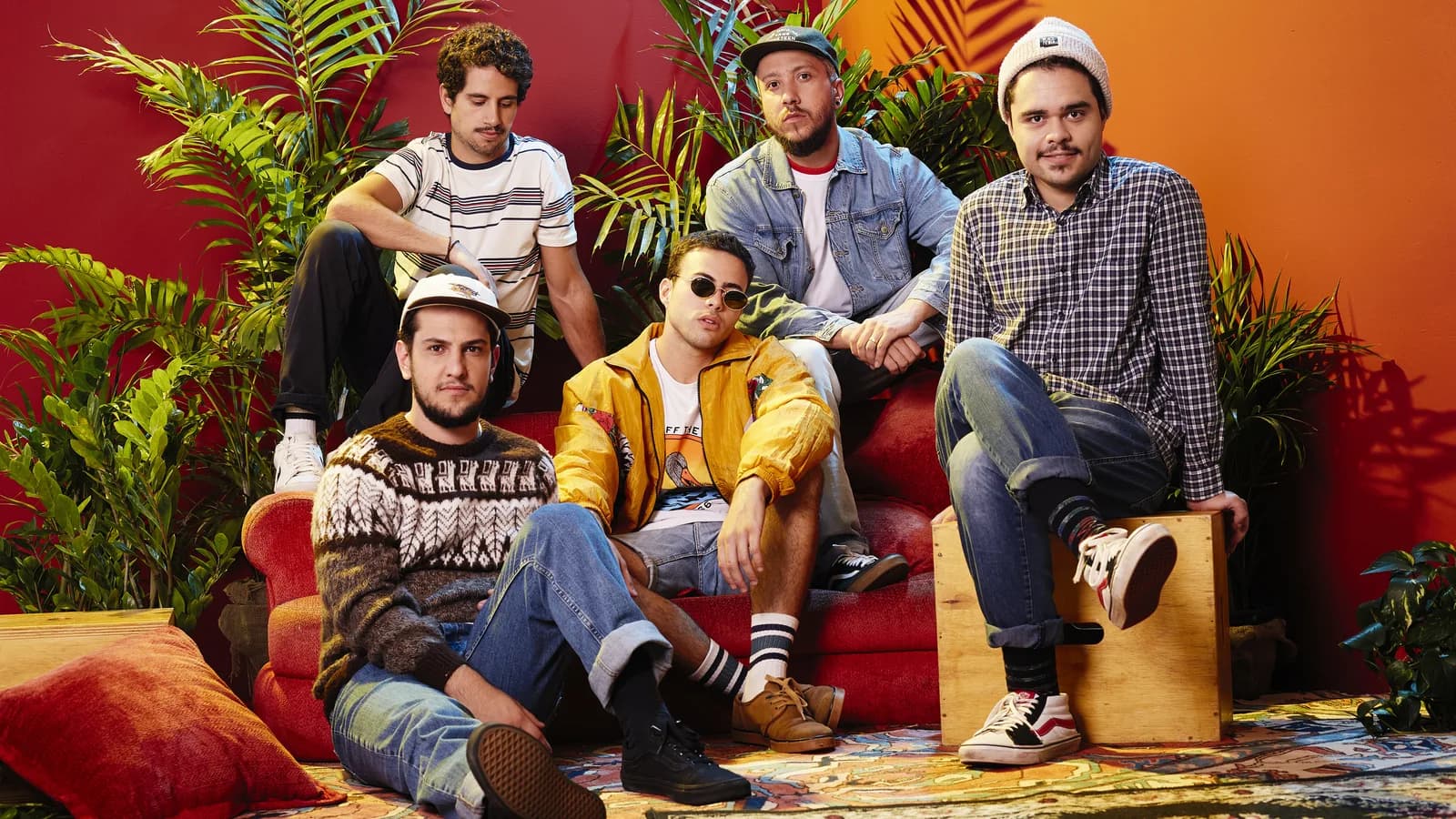 Os cinco integrantes da banda Lagum posam juntos em estúdio decorado com plantas
