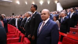 Autoridades em pé no plenário do Tribunal Superior Eleitoral, em Brasília, durante cerimônia oficial da Corte