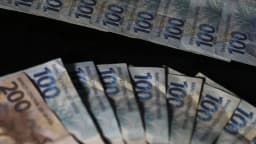 Notas de real em dinheiro, em referência às dívidas e renegociações de crédito rural no agronegócio