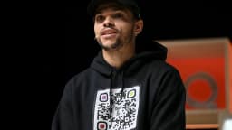 Martin Braithwaite em evento Web Summit, usando moletom com QR code