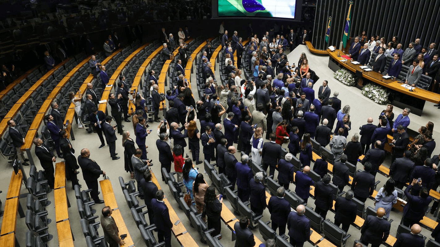 Plenário da Câmara dos Deputados lotado durante sessão solene, com parlamentares em pé